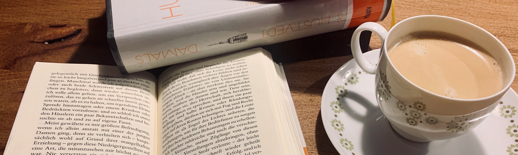 Tasse mit aufgeschlagenem Buch