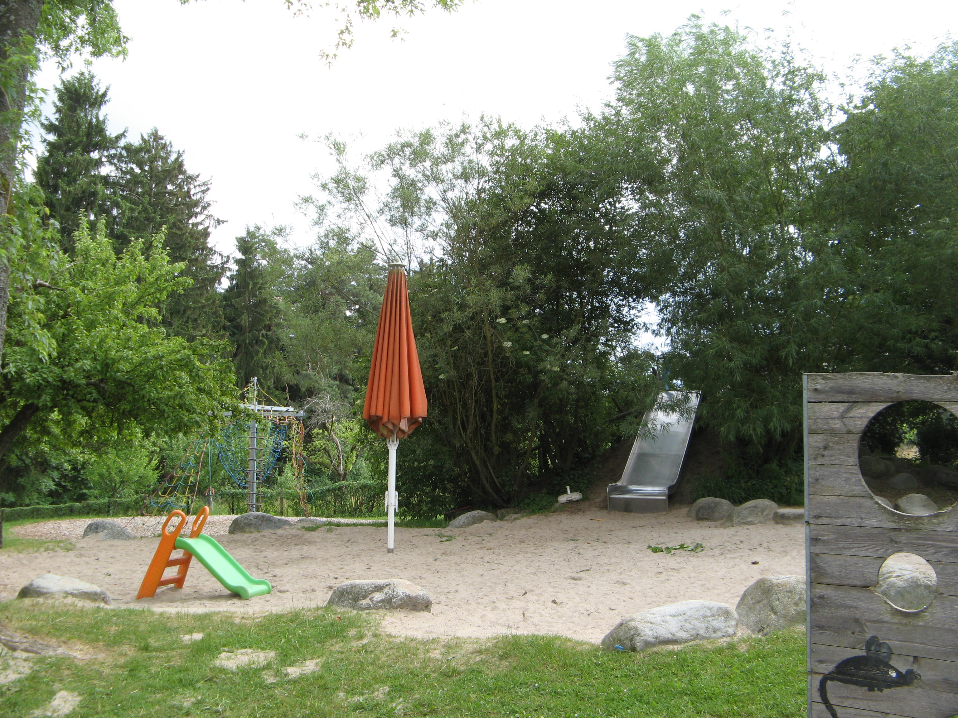 Sandspielbereich mit Torwand, Rutsche und Klettergerät