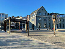 großer Platz mit Säulen und einem Haus im Hintergrund (Egeriaplatz in Lustnau)