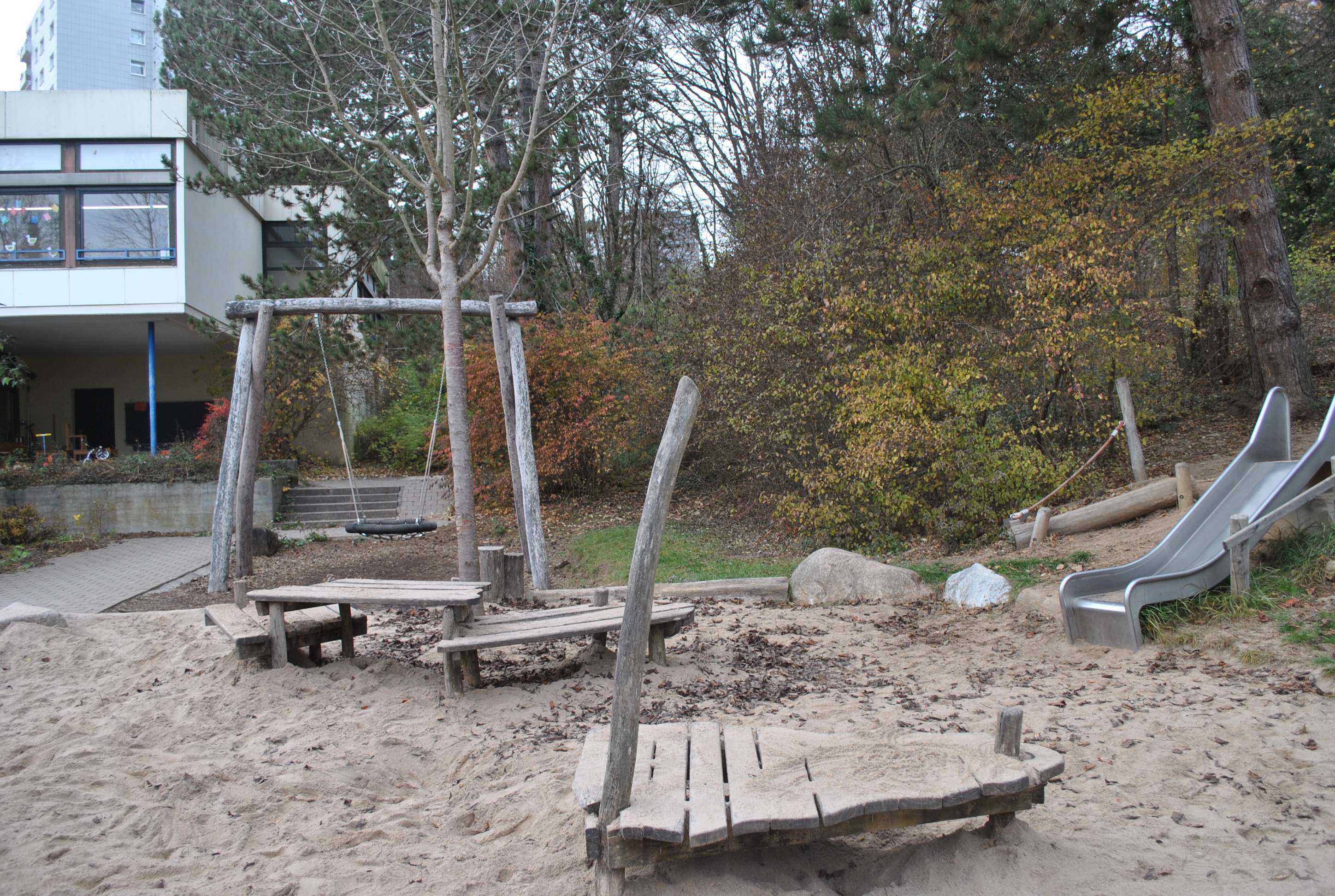 Sandspielbereich mit Klettergeräten aus Holz