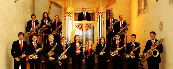 Das Foto zeigt das Tübinger Saxophon-Ensemble vor einer kleinen Kirchenorgel