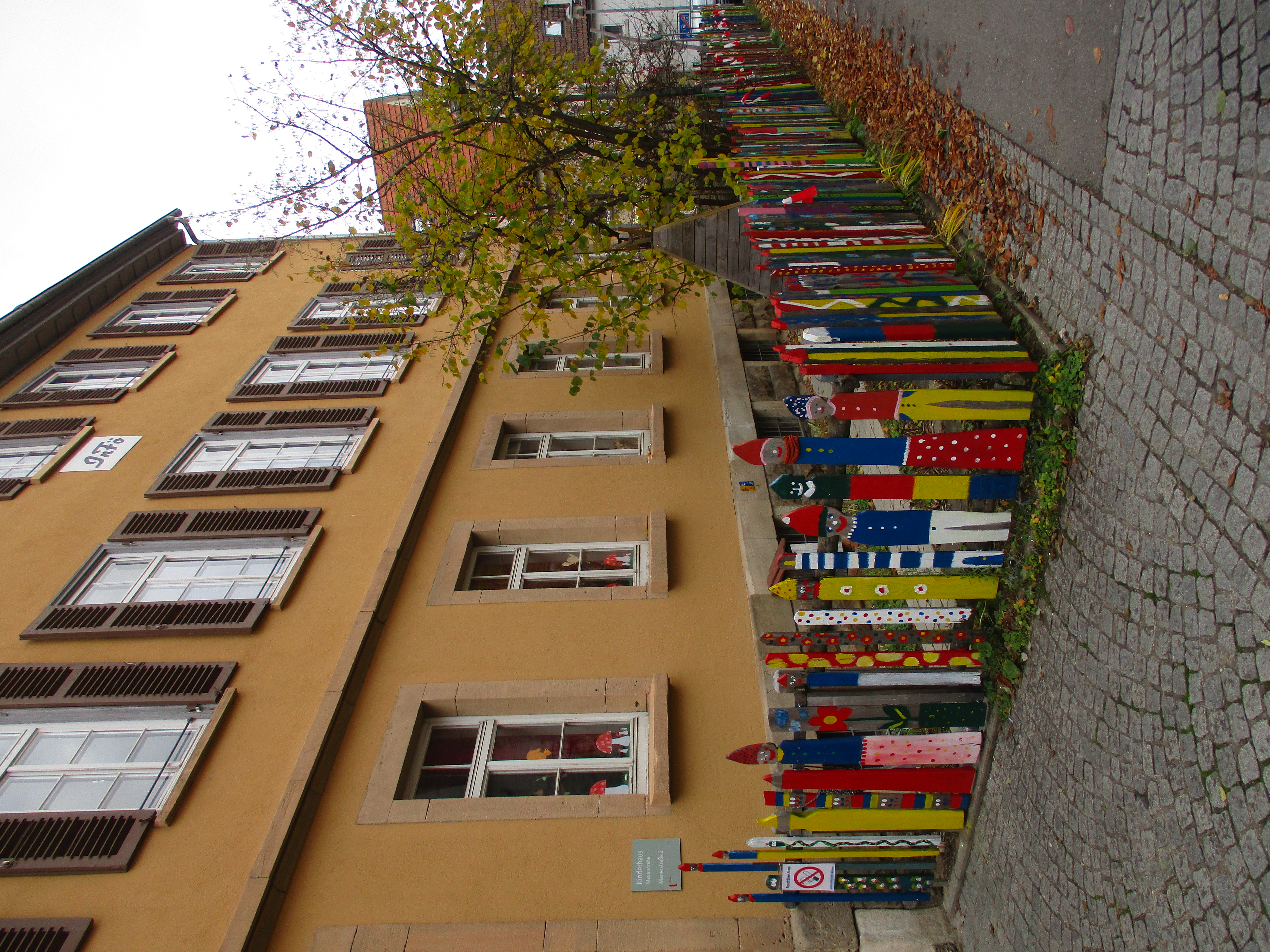 Hauseingang mit vielen bunt bemalten Holzpfosten