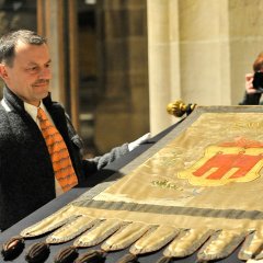 Stadtarchivar Udo Rauch präsentiert die Stadtfahne, die Herzog Ulrich den Tübingern nach der Niederschlagung des Armen Konrads überreicht haben soll. Bild: Gudrun de Maddalena