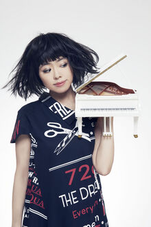 Das Bild zeigt die Jazz-Pianistin Hiromi mit einem Spielzeug-Klavier