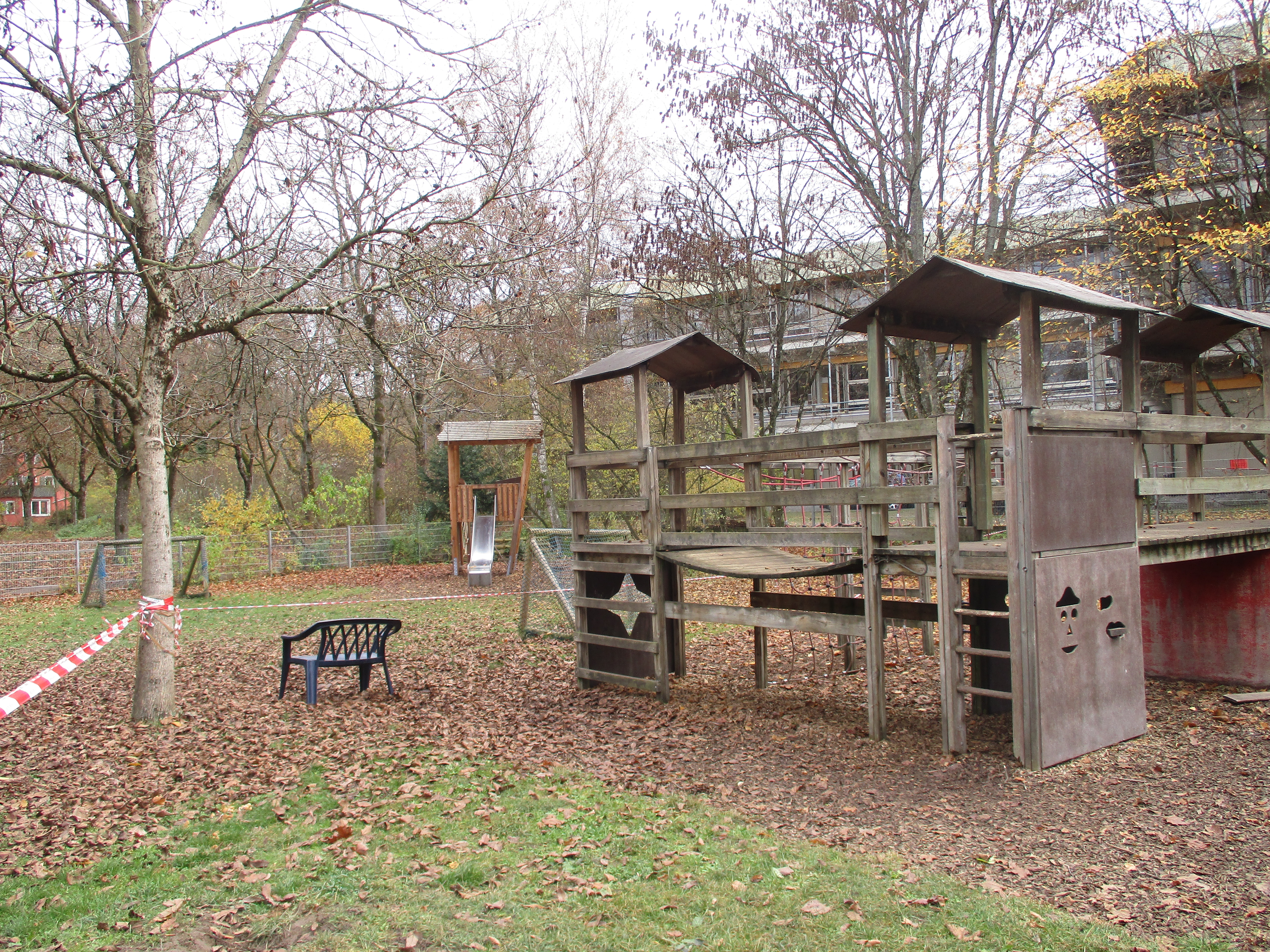 Das bIld zeigt den hinteren Garten des Kinderhaus Feuerhägle. Es ist im Hintergrund eine Rutsche erkennbar. Im Vordergrund kann man ein großes Klettergerüst aus Holz sehen.