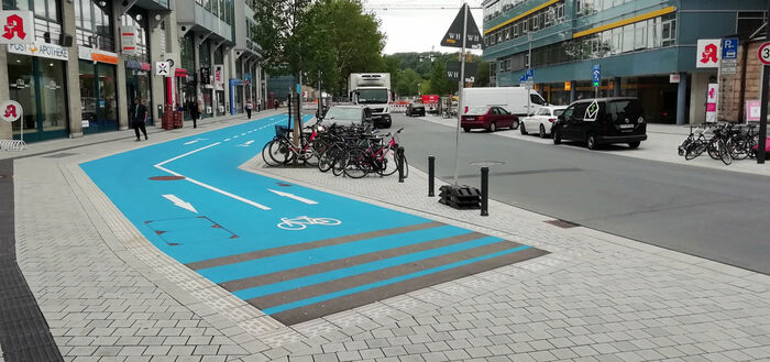 Es ist die umgebaute Europastraße mit dem Blauen Band für Radfahrende zu sehen