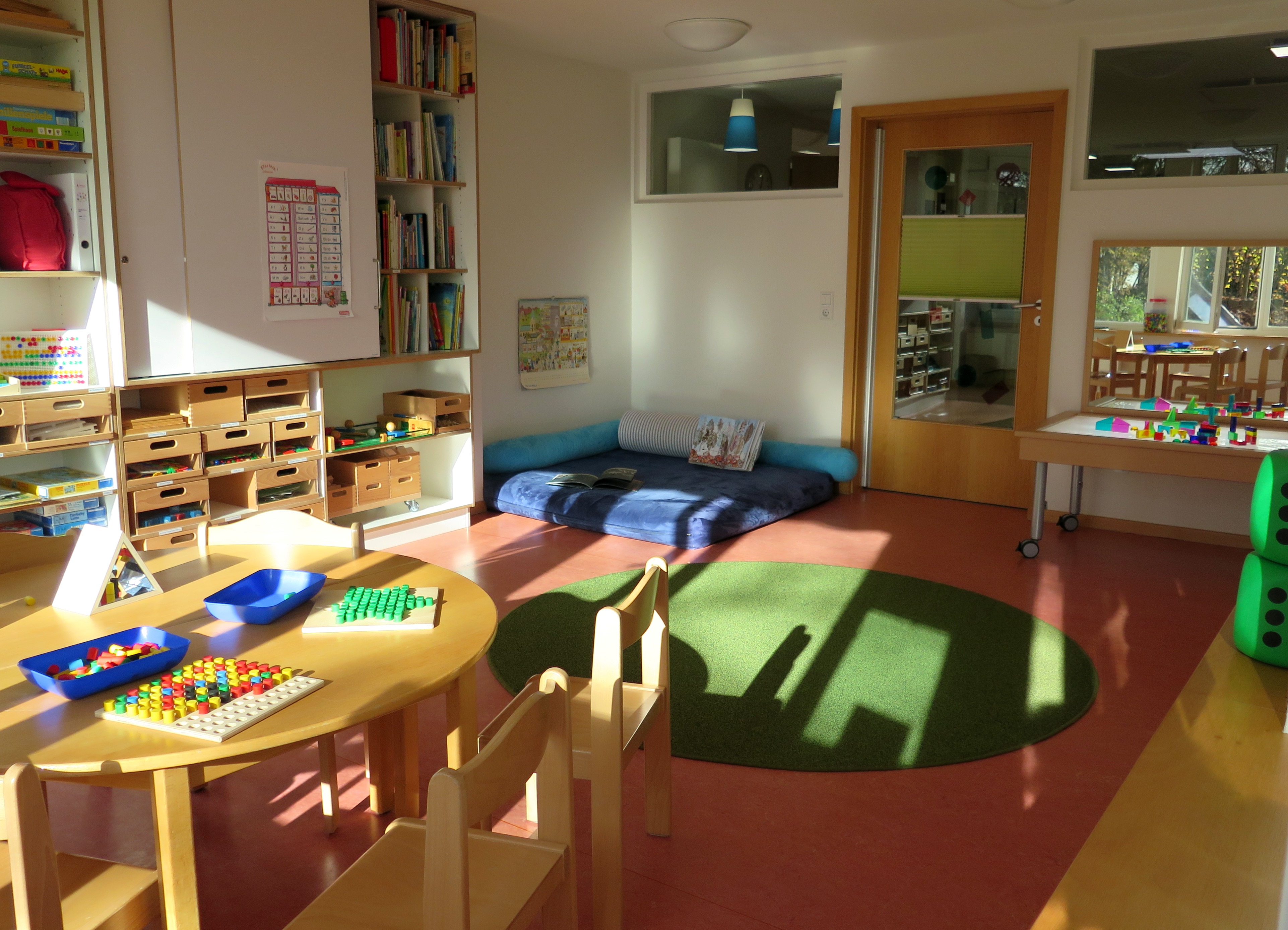 Tisch mit Spielsachen und Teppich für Spiele auf dem Boden