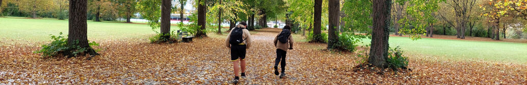 Zwei Kinder auf dem Schulweg durch einen Park