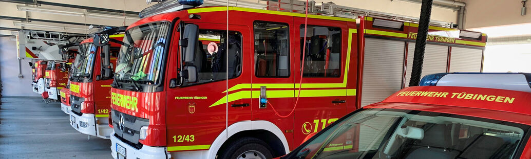 Mehrere Feuerwehrautos stehen nebeneinander in einer Garage.