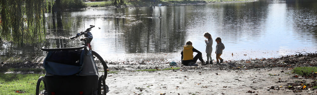 Eine Frau und zwei Kinder stehen am Wasser