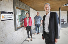 OB Boris Palmer, Miriam Ibrahimovic und Bernd Walter sind am Bergfriedhof vor dem Schild der Auszeichnung zum immateriellen Erbe Friedhofskultur zu sehen.