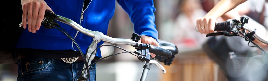 Zwei Personen mit Fahrradlenkr&auml;dern in den H&auml;nden