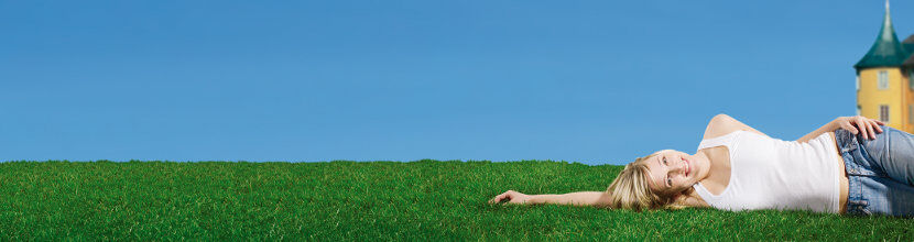 Bild: junge Frau auf gr&uuml;ner Wiese vor H&ouml;lderlinturm unter blauem Himmel