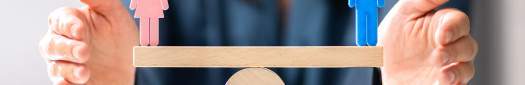 H&auml;nde halten eine Waage auf der eine Frau und ein Mann stehen