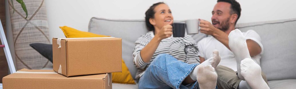 Paar auf Sofa mit Umzugskisten