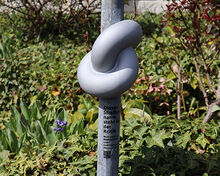 gro&szlig;er Knoten, der an einem Stra&szlig;enschild befestigt ist