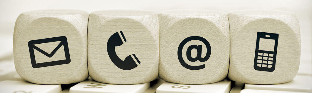 vier W&uuml;rfel mit Symbolen (Brief, Telefonh&ouml;rer, @, Handy) liegen nebeneinander