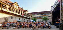 Es ist das Publikum der Schlosshofkonzerte vom letzten Jahr zu sehen, die seitlich, zur B&uuml;hne schauend, fotografiert wurden.