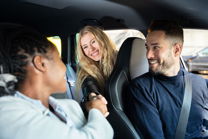 Drei Personen sitzen in einem Auto