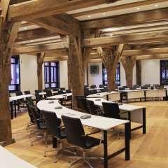 Im Ratssaal sorgen wei&szlig;e, leichte Tische im Halbrund f&uuml;r einen reizvollen Kontrast zu den schweren Eichenst&uuml;tzen. Bild: Universit&auml;tsstadt T&uuml;bingen.