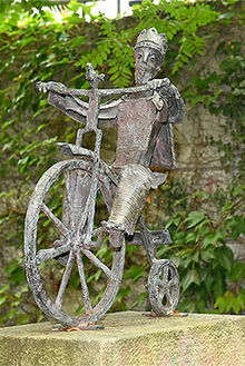 Eine Bronzeskulptur, die einen K&ouml;nig auf seinem Fahrrad darstellt 